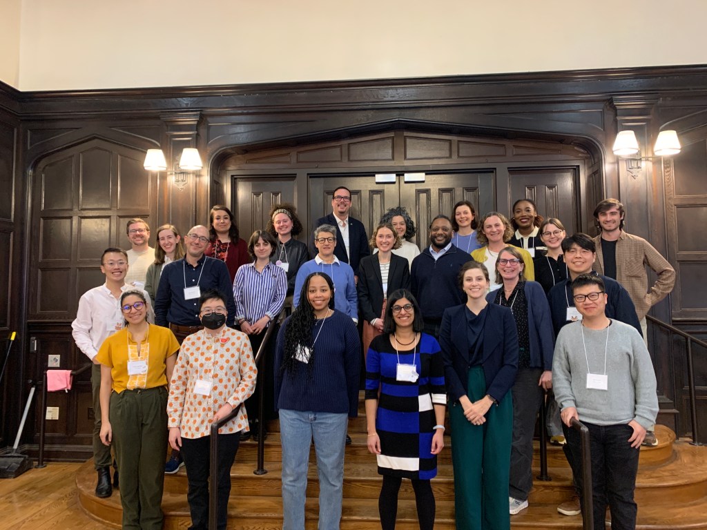 Conference participants at Yale University, standing on a short set of stairs smiling.